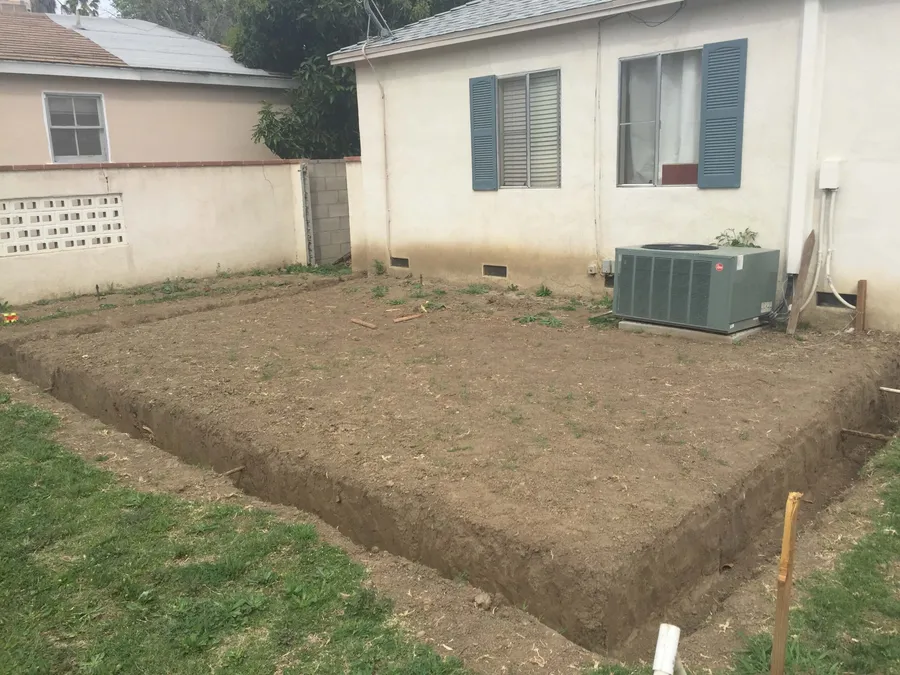 Backyard with a leveled and trenched footprint ready for a room addition